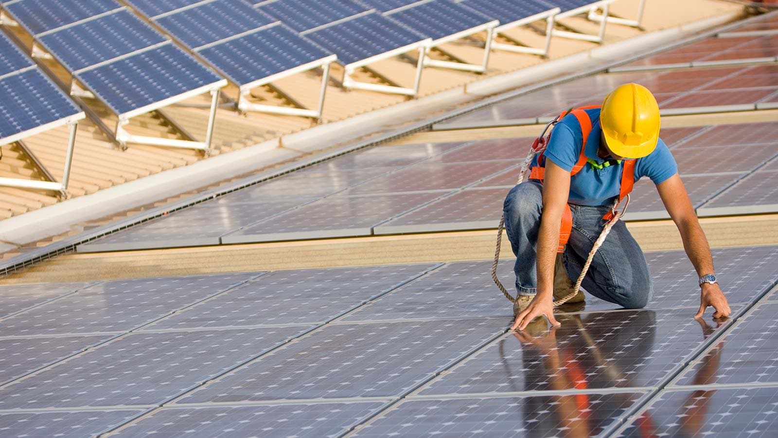 Mann auf Solaranlage auf dem Dach