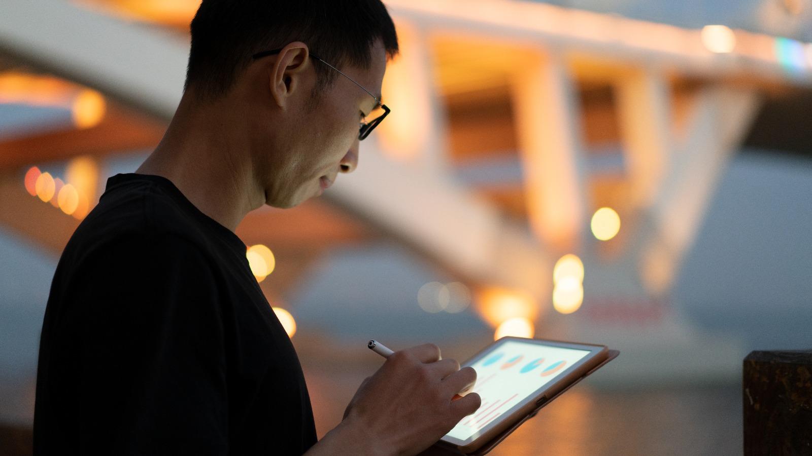 Asiate arbeitet mit Touchpad auf Tablet