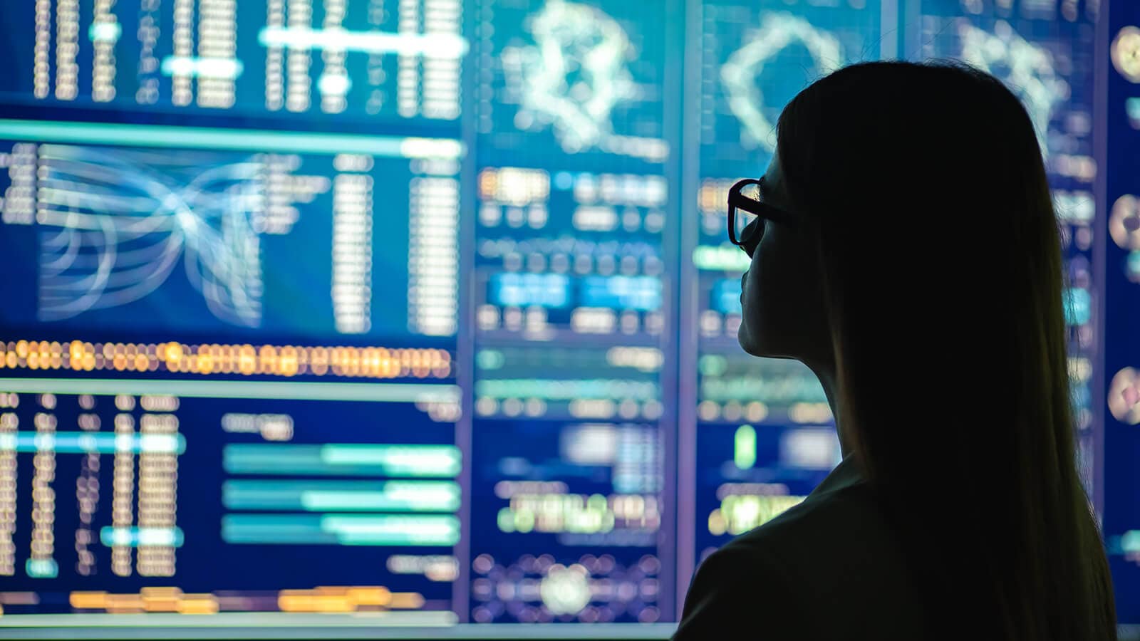 Frau vor Datenbildschirmen