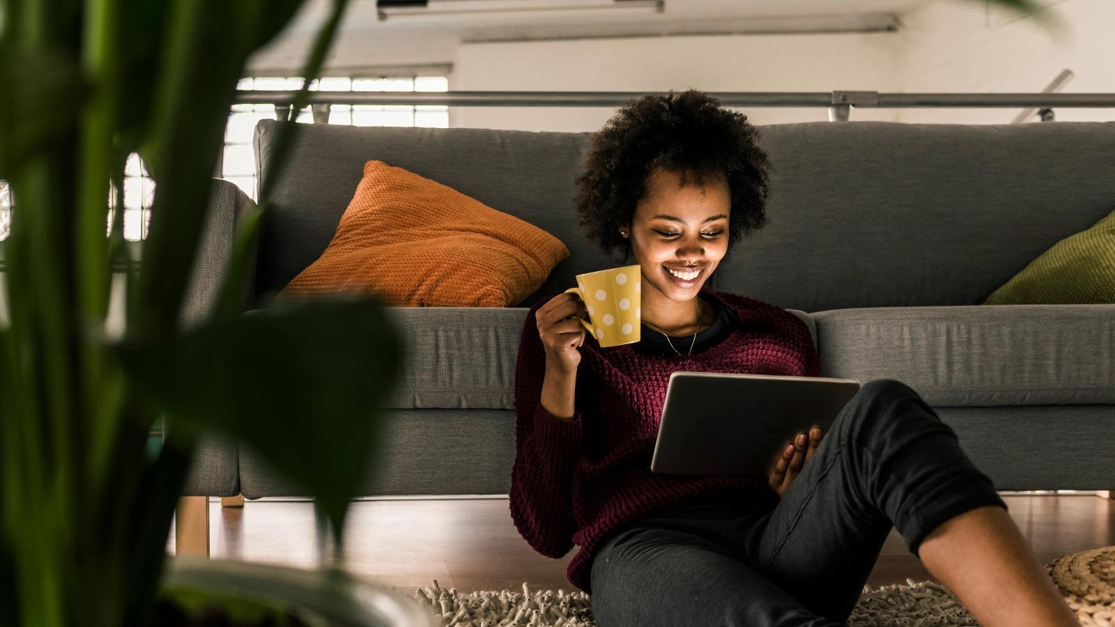 Frau mit Kaffee am Tablet