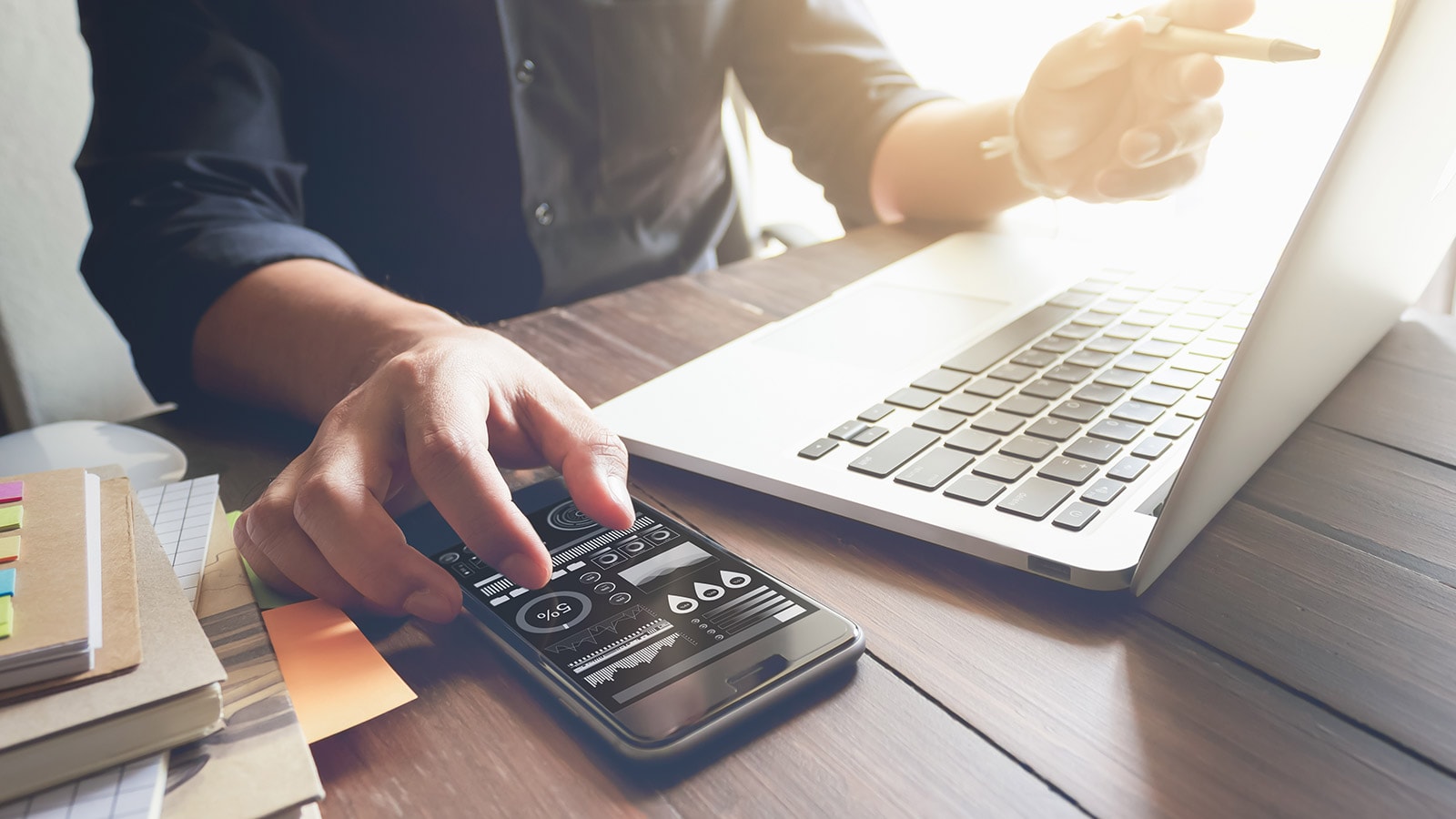 Mann mit Smartphone und Laptop