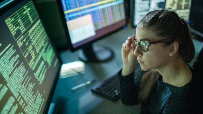 Junge Frau vor einem Monitor mit Daten