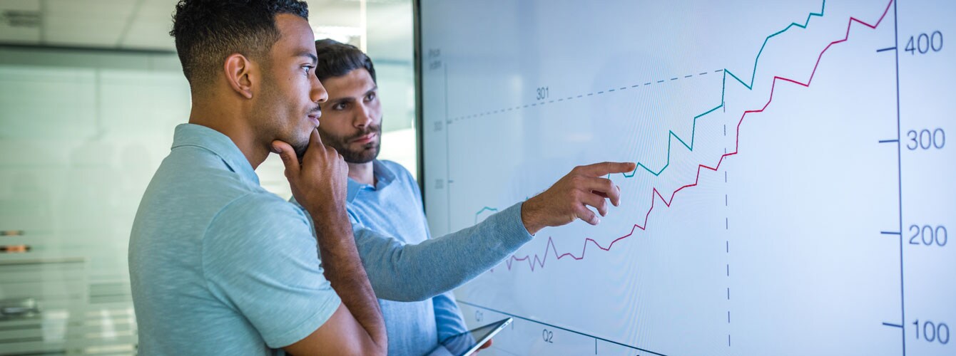 Two men are checking the statistics on whiteboard