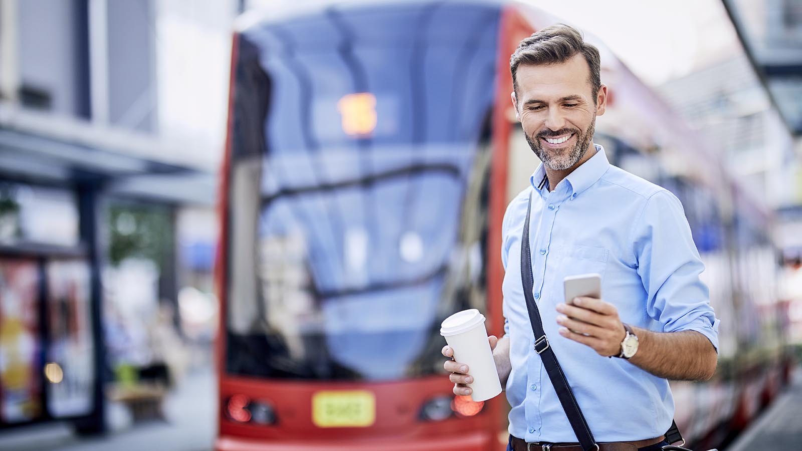 Mann mit Handy vor Tram