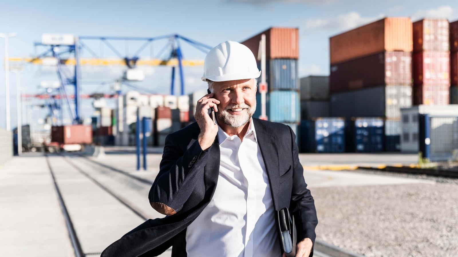 Mann mit Helm am Containerhafen