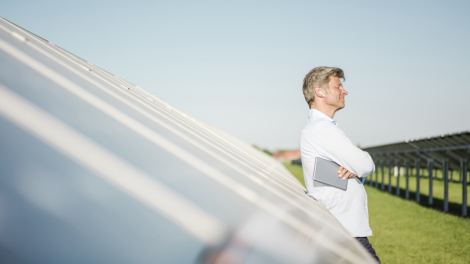 Mann lehnt an Solaranlage