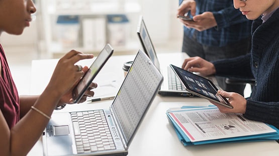 Menschen arbeiten an Laptops und Smartphones
