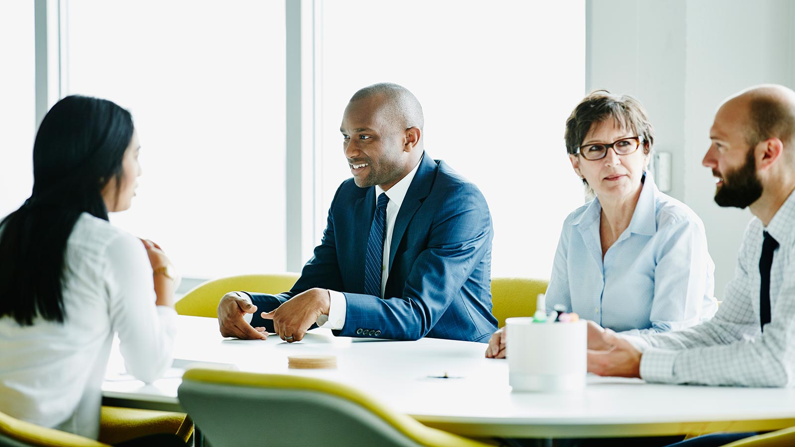 Vier Personen im Meeting an Tisch