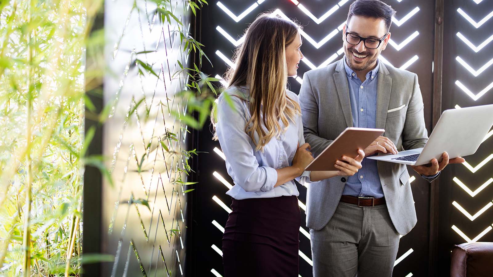 Frau und Mann mit Laptop und Notizen im Gespräch