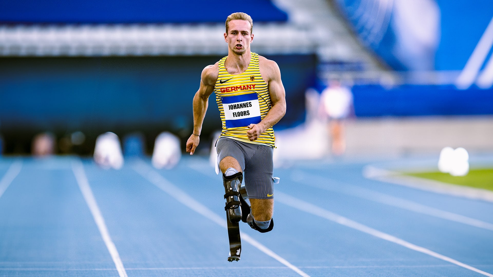 Der Para-Leichtathlet Johannes Floors sprintet auf einer blauen Tartanbahn				 				 				 				 				 				 				 				 				 				 				 				